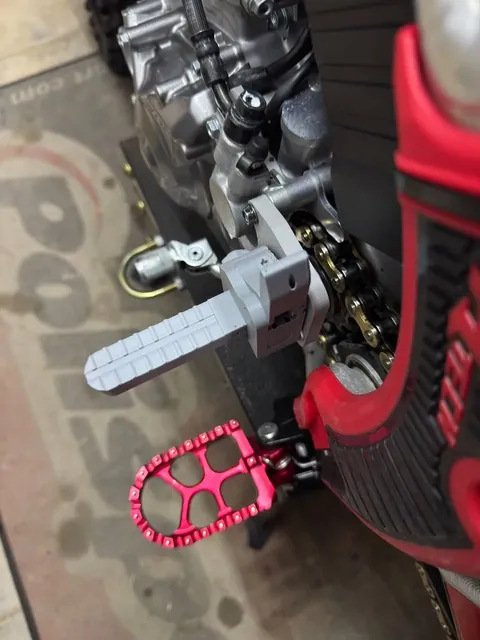 Side view of the printed prototype footpeg and the red CNC footpeg